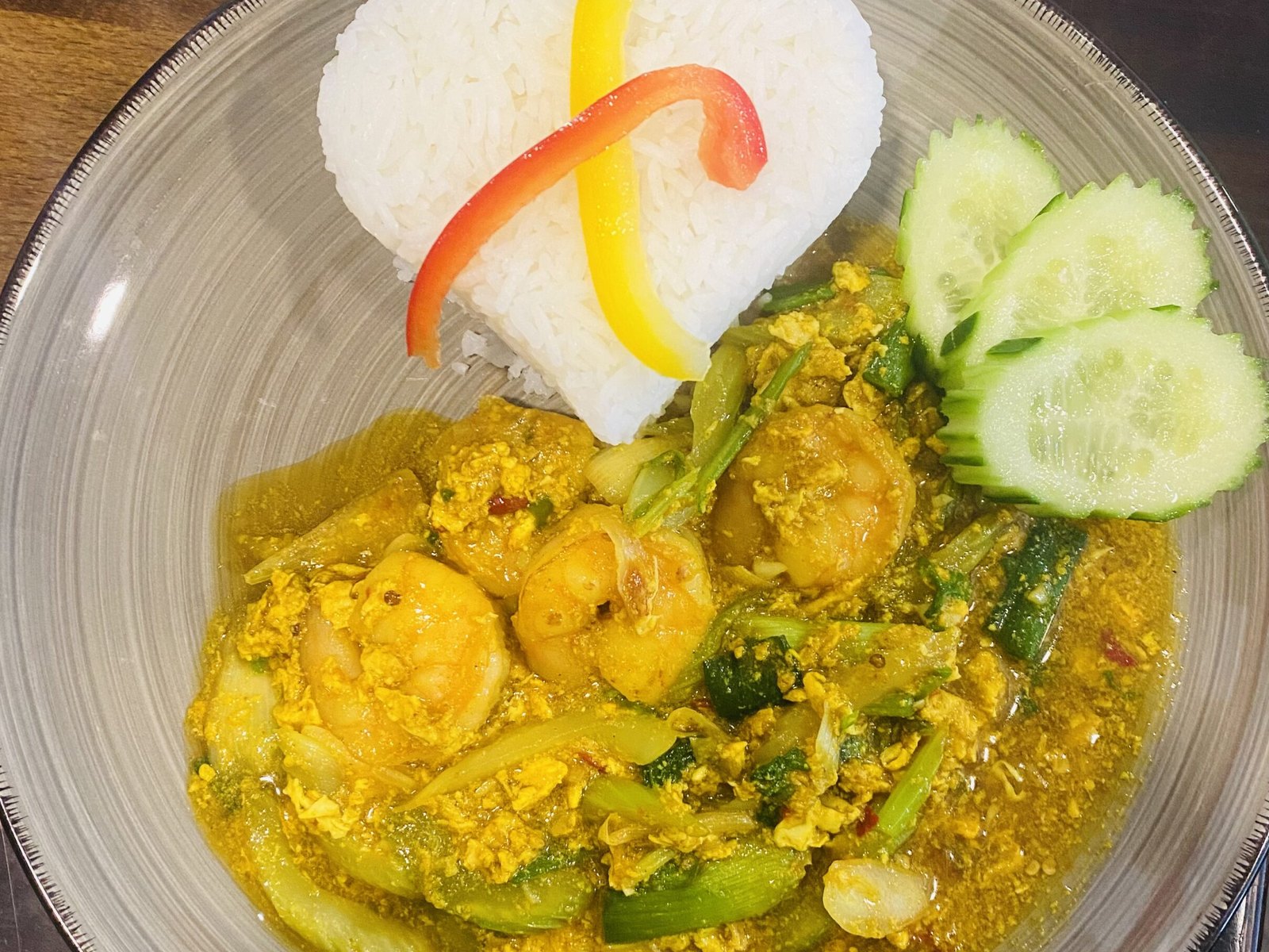 Phad Phongkra Hri Gung: Garnelen mit Currypulver, Ei und Gemüse, Reis in Herzform mit Paprikastreifen, Gurkenscheiben